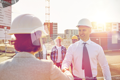 Image of builders making handshake on construction site