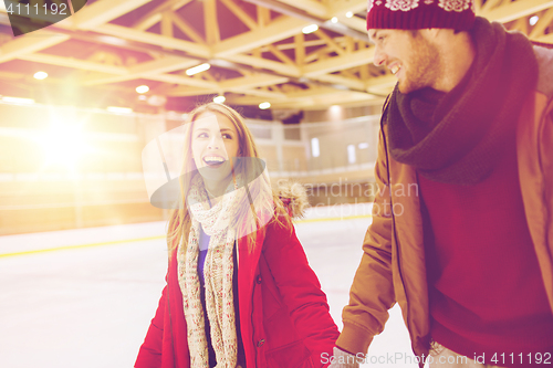 Image of happy couple holding hands on skating rink