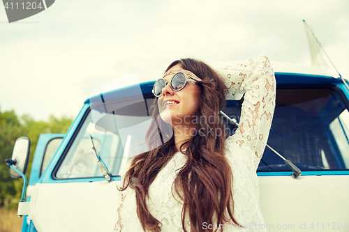 Image of smiling young hippie woman in minivan car