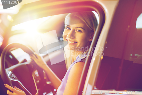 Image of happy woman inside car in auto show or salon