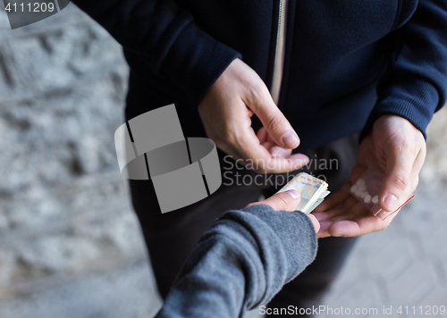 Image of close up of addict buying dose from drug dealer