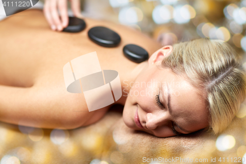 Image of close up of woman having hot stone massage in spa