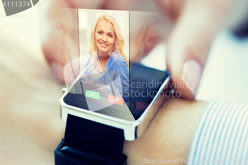 Image of close up of hand with incoming call on smart watch