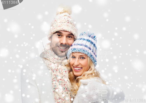 Image of smiling couple in winter clothes hugging