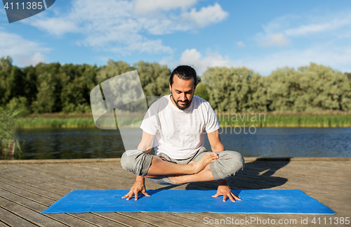 Image of man making yoga in scale pose outdoors