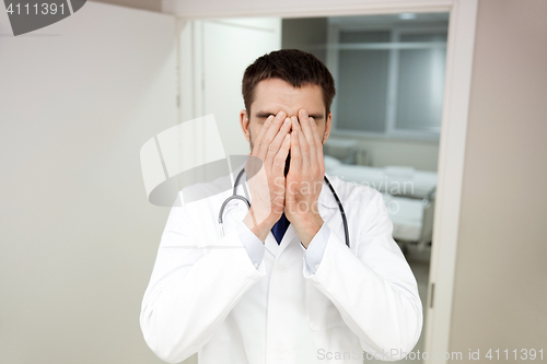 Image of sad or crying male doctor at hospital ward