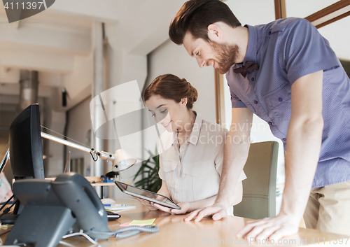 Image of happy creative team with tablet pc in office