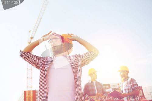 Image of group of builders in hardhats outdoors