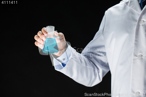 Image of close up of scientist holding flask with chemical