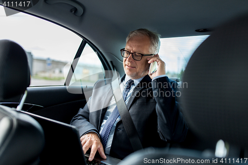 Image of senior businessman calling on smartphone in car