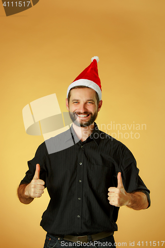 Image of Smiling christmas man wearing a santa hat