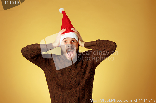 Image of Surprised christmas man wearing a santa hat