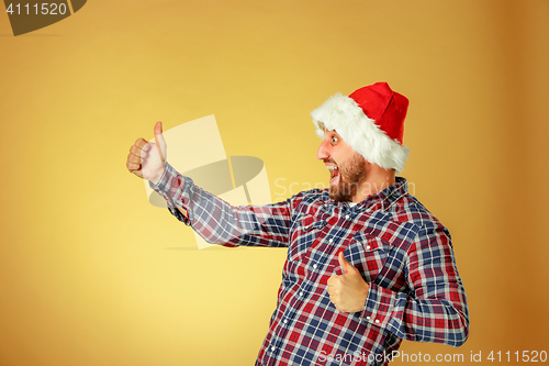 Image of Smiling christmas man wearing a santa hat