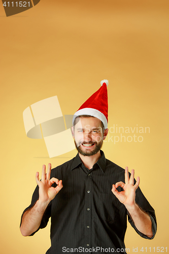 Image of Smiling christmas man wearing a santa hat