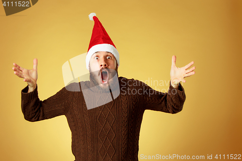 Image of Surprised christmas man wearing a santa hat