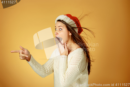 Image of Surprised christmas girl wearing a santa hat