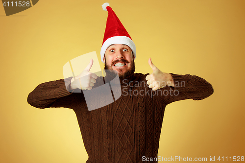 Image of Smiling christmas man wearing a santa hat