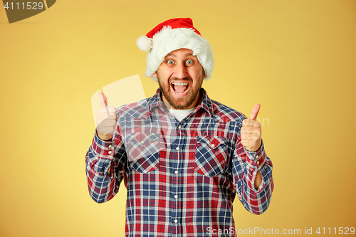 Image of Smiling christmas man wearing a santa hat