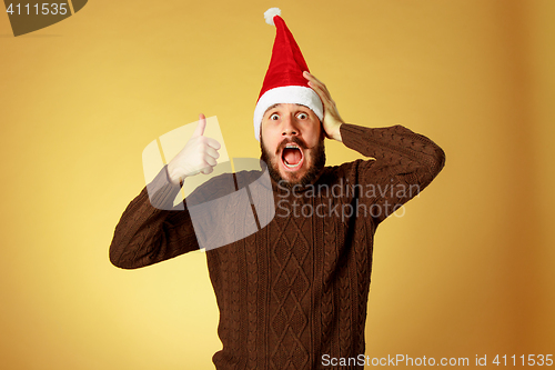 Image of Smiling christmas man wearing a santa hat