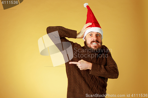 Image of The serious christmas man wearing a santa hat