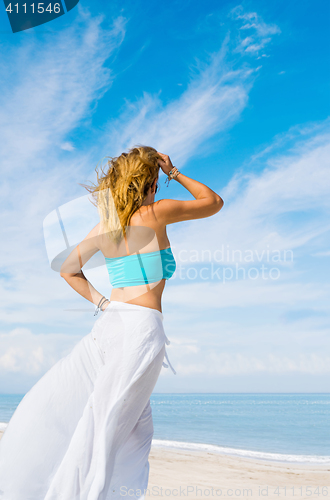 Image of portrait of young pretty woman looking to the ocean 