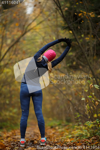 Image of Young blonde on stretching exercises in autumn park