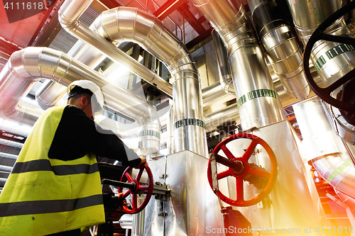 Image of factory worker turning valve