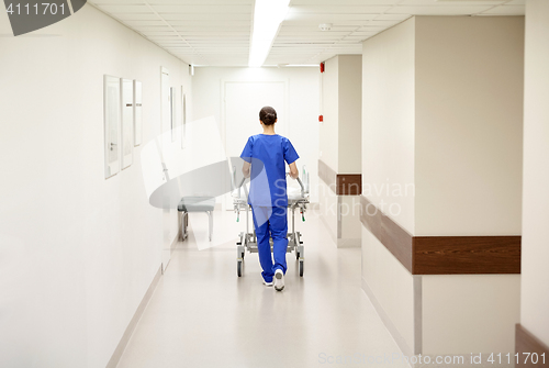 Image of nurse carrying hospital gurney to emergency room