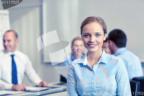 Image of group of smiling businesspeople meeting in office