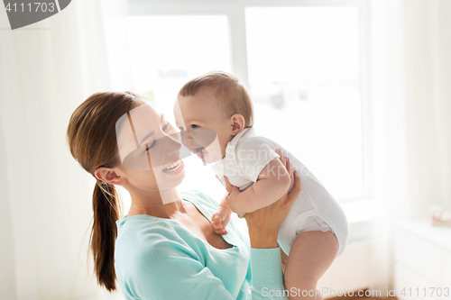 Image of happy young mother with little baby at home