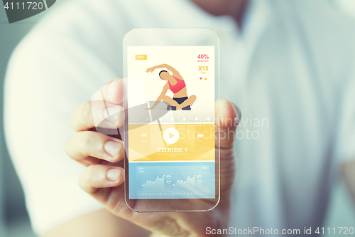 Image of close up of hand with sport app on smartphone