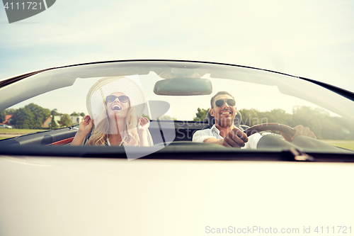 Image of happy man and woman driving in cabriolet car