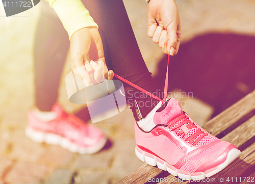 Image of runner woman lacing trainers shoes