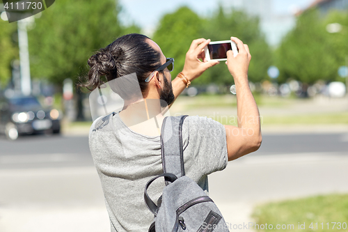 Image of hipster man taking picture on smartphone