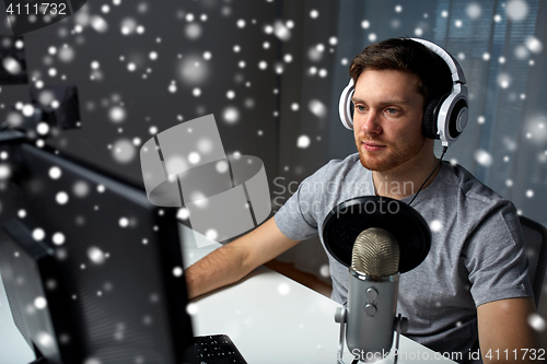 Image of man in headset playing computer video game at home