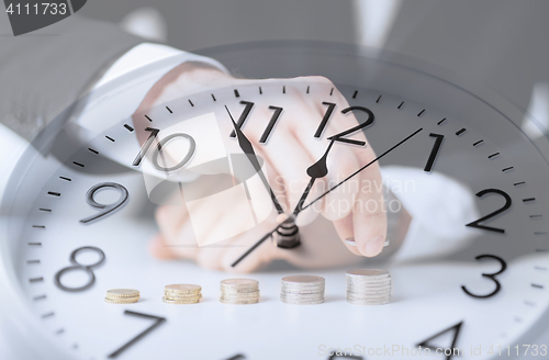 Image of clock over businessman counting euro coins