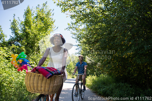 Image of Young multiethnic couple having a bike ride in nature