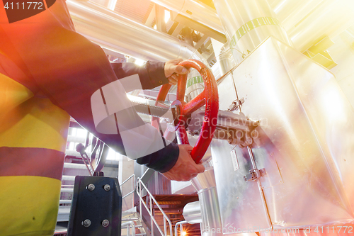 Image of factory worker turning valve