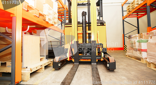 Image of Forklift, shelves and racks with pallets in distribution warehou