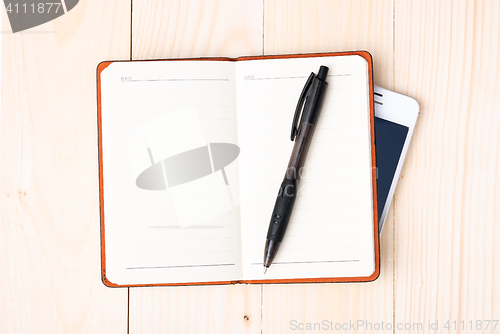 Image of Small notepad with pen and smartphone