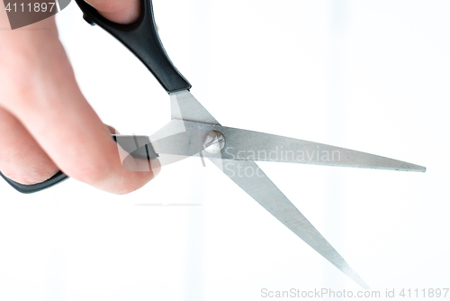 Image of the hand holds the scissors for thinning out on an isolated white background