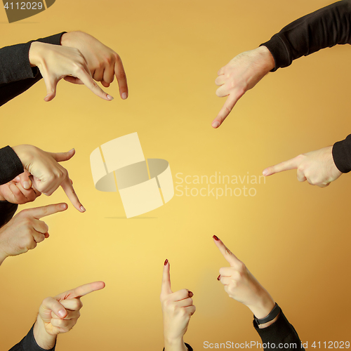 Image of Many hands pointing ahead or out on orange background