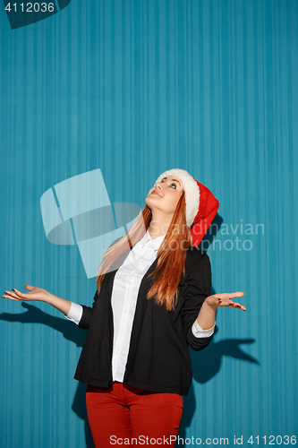 Image of Surprised christmas girl wearing a santa hat