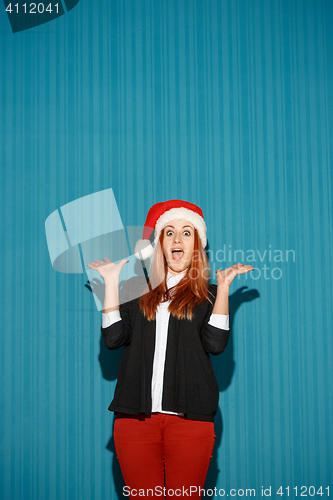 Image of Surprised christmas girl wearing a santa hat