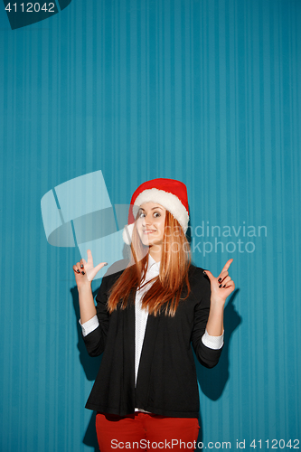 Image of Surprised christmas girl wearing a santa hat