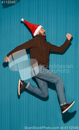 Image of The running christmas man wearing a santa hat