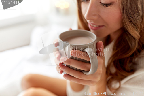 Image of close up of happy woman with cocoa cup at home