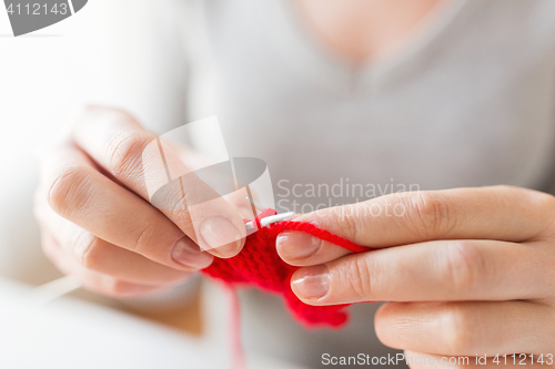 Image of close up of hands knitting with needles and yarn