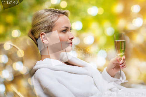 Image of beautiful young woman drinking champagne at spa