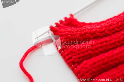 Image of hand-knitted item with knitting needles